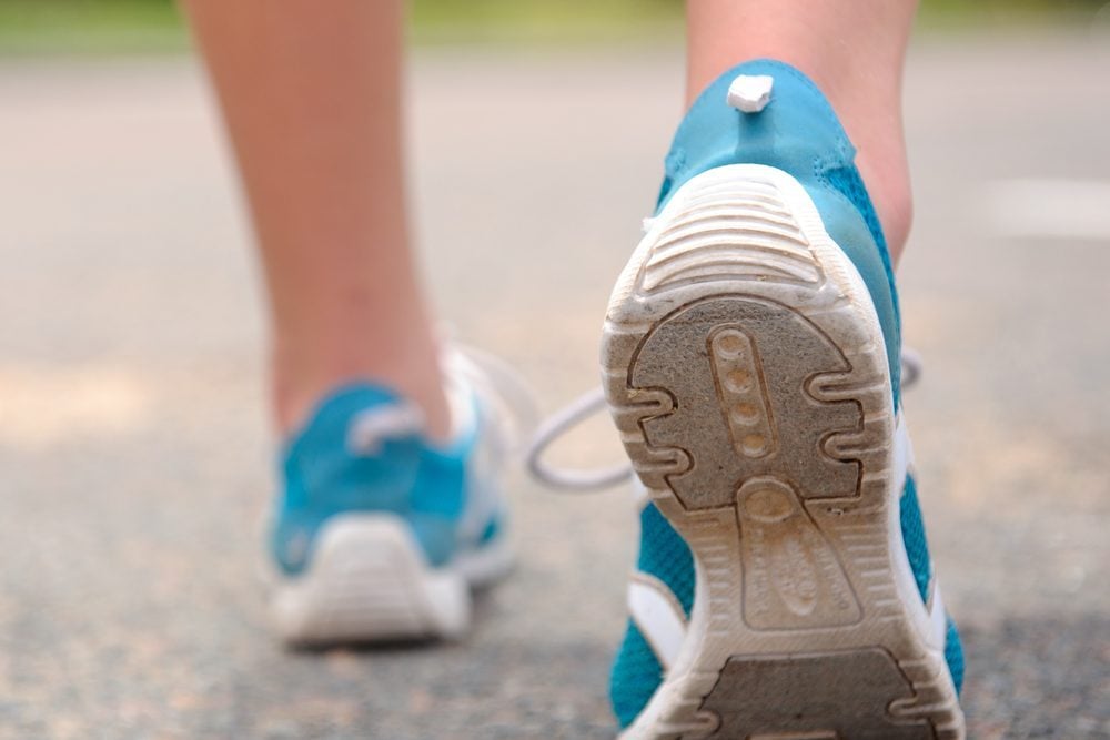 Close up motion shot of person walking away in running shoes
