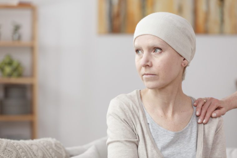 Sad sick woman with lung cancer sitting at home with friend