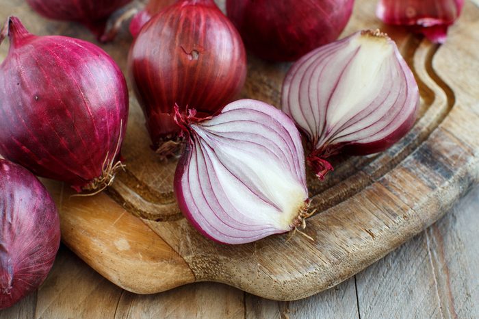 Red onions on a wooden board close up
