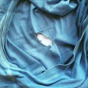 Old, worn blue t-shirt with hole