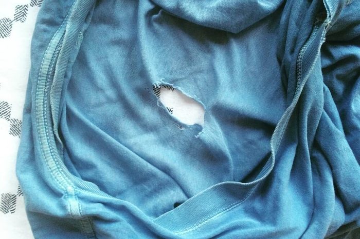 Old, worn blue t-shirt with hole