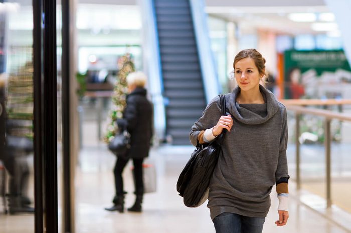 Young woman looking at store windows when shopping in a shopping mall/center