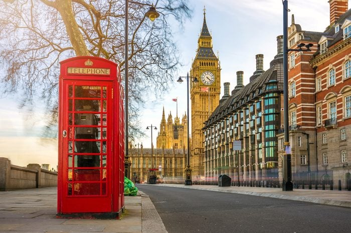 London, England - The iconic british old red telephone box with the Big Ben at background in the center of London at sunset