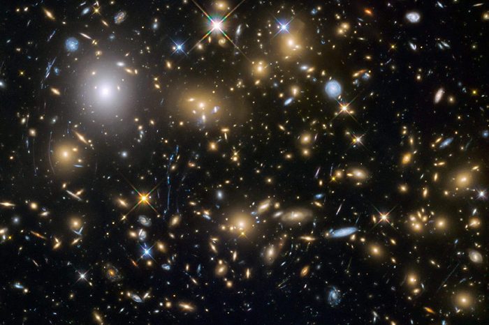 Observations by the NASA/ESA Hubble Space Telescope have taken advantage of gravitational lensing to reveal the largest sample of the faintest and earliest known galaxies in the universe. Some of these galaxies formed just 600 million years after the big bang and are fainter than any other galaxy yet uncovered by Hubble. The team has determined for the first time with some confidence that these small galaxies were vital to creating the universe that we see today. An international team of astronomers, led by Hakim Atek of the Ecole Polytechnique Fédérale de Lausanne, Switzerland, has discovered over 250 tiny galaxies that existed only 600-900 million years after the big bang— one of the largest samples of dwarf galaxies yet to be discovered at these epochs. The light from these galaxies took over 12 billion years to reach the telescope, allowing the astronomers to look back in time when the universe was still very young.