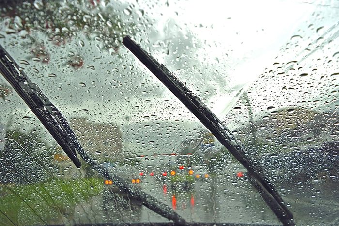Windshield wipers from inside of car, season rain. traffic jam.