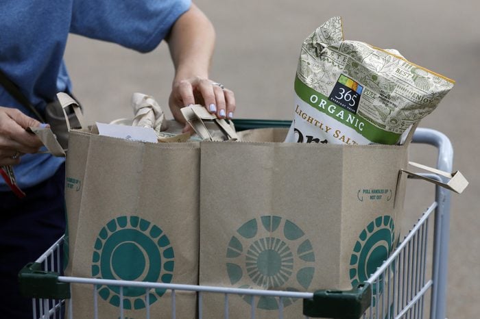 A Whole Foods Market customer prepares to remove her purchases from a shopping basket outside the Jackson, Miss., store, . Amazon is buying Whole Foods Market in a deal valued at $13.7 billion, uniting the on-line giant with the grocery store chain that touts fresh organic foods