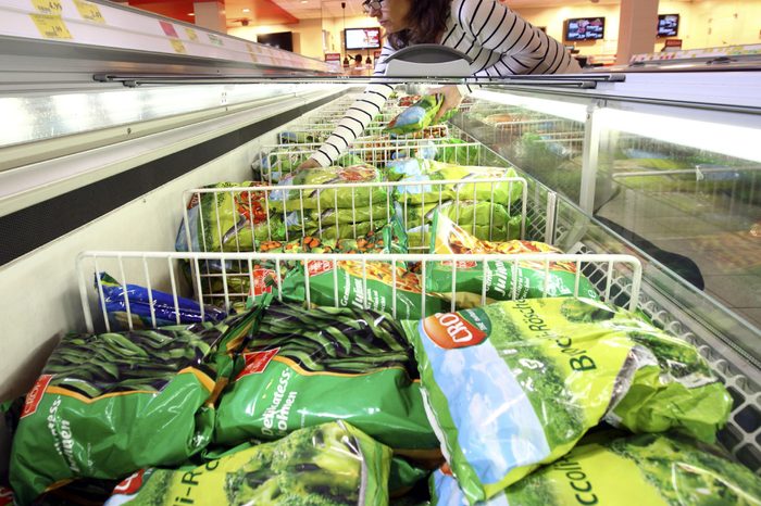MODEL RELEASED Woman purchasing frozen vegetables in the frozen food section of a self-service grocery department, supermarket, Germany