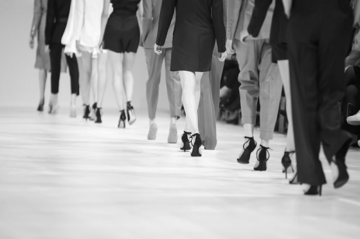 Fashion Show, Catwalk Runway Show Event. Detail of lined up rear view fashion models legs with high heels.