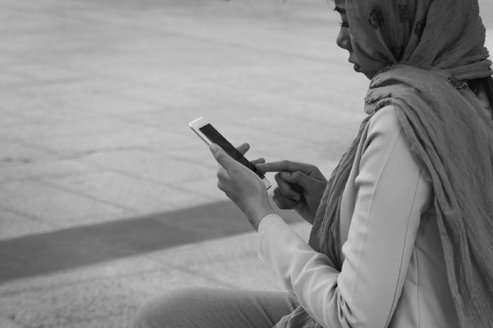 Arab businesswoman messaging on a mobile phone in the city