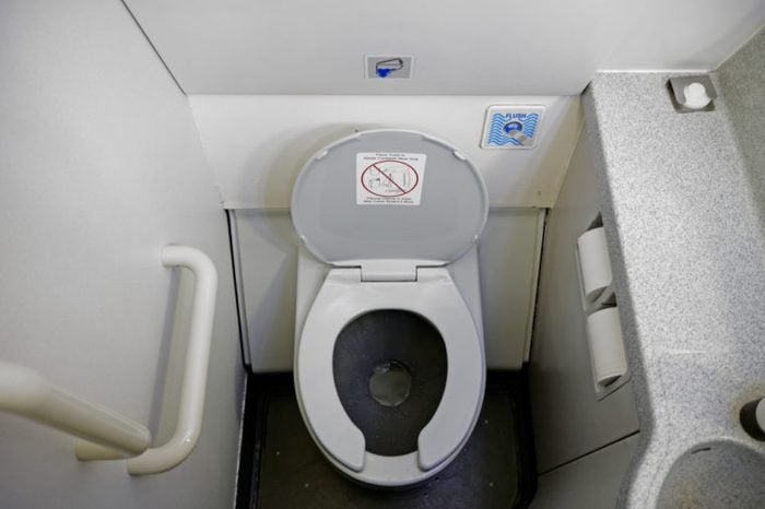 The cramped and dirty bathroom of a commercial airliner. 