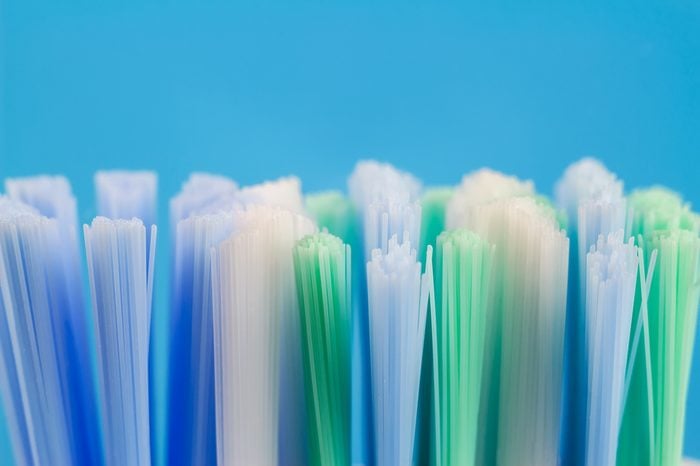 Macro photo of toothbrush isolated on blue background