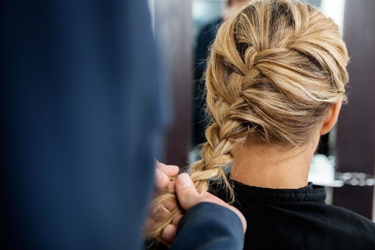 Cropped Image Of Hairdresser Braiding Client's Hair