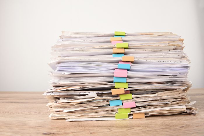 Pile of Financial documents with colorful clips on wood desk stack up,back isolated background