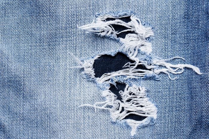 A closeup picture of a part of the jeans that is a bit torn