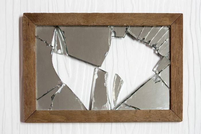 Broken mirror on white wooden