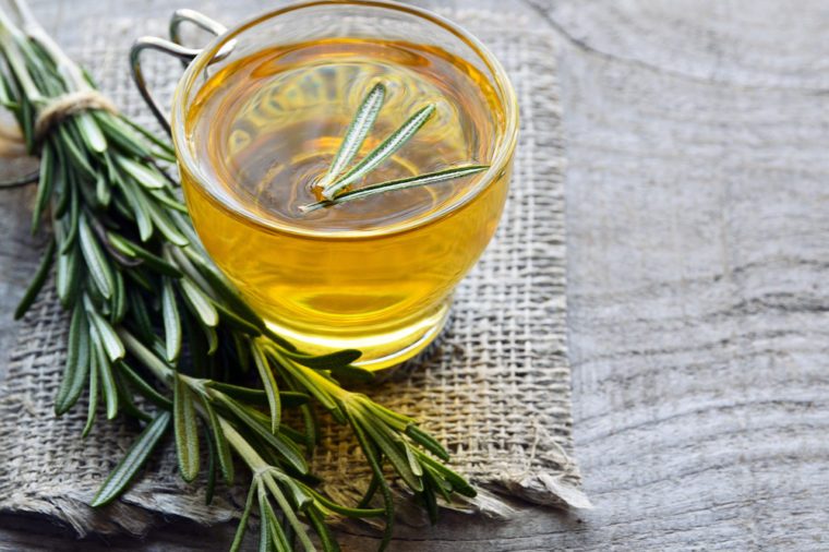 Rosemary herbal tea in a glass cup on rustic wooden background with copy space.Rosemary tea.Selective focus.