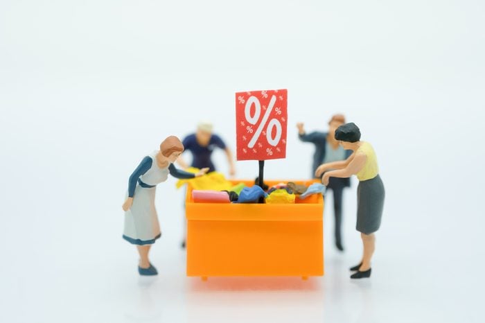 Miniature people: Shoppers with discount tray for shopping discounted items using as background business concept.