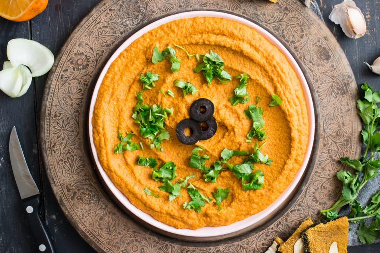 Israel creamy chickpeas hummus plate with carrot and olive oil. Traditional israeli food. Raw vegan vegetarian healthy food