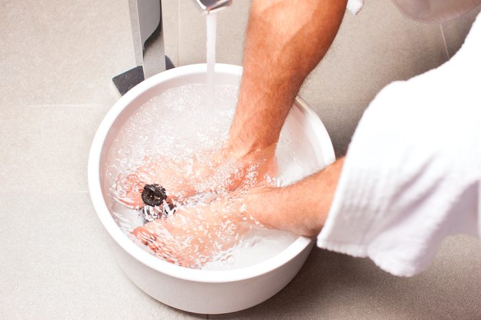 Man having hydrotherapy water footbath in spa setting