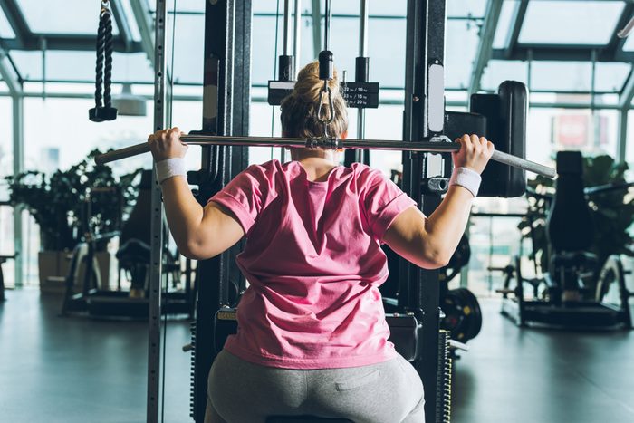 overweight woman working out on training apparatus
