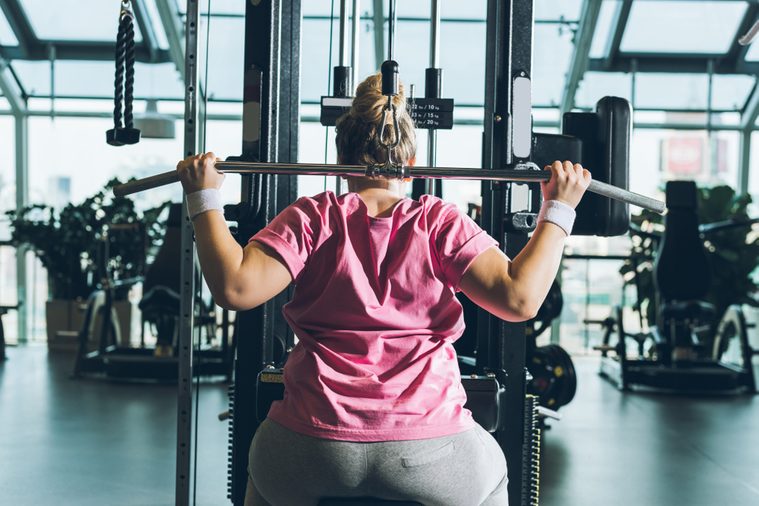 overweight woman working out on training apparatus 