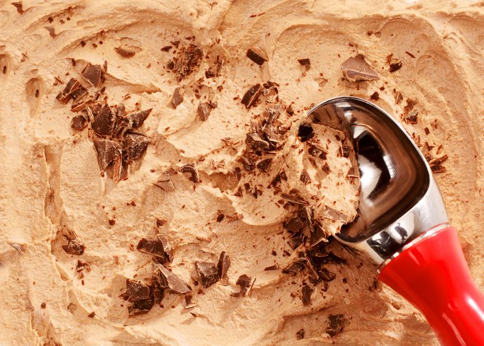 High Angle Close Up View of Red Handled Scoop Serving Mocha or Coffee Flavored Ice Cream Topped with Chocolate Shavings