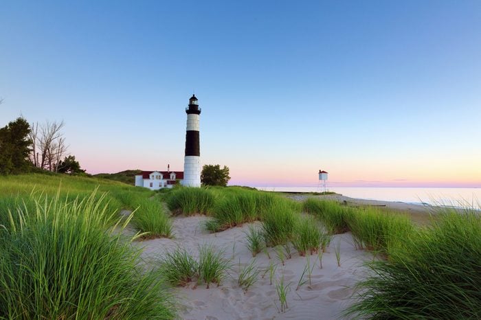 Big Sable Point Lighthouse in Ludington State Park on a Lake Michigan beach. Sunset hues in the background.