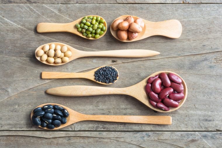 Group of beans and lentils in spoon made wood on wodden background. mung bean, groundnut, blackbean, black seasame, red kidney bean