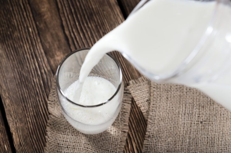 Portion of Milk on a dark wooden background (close-up shot)