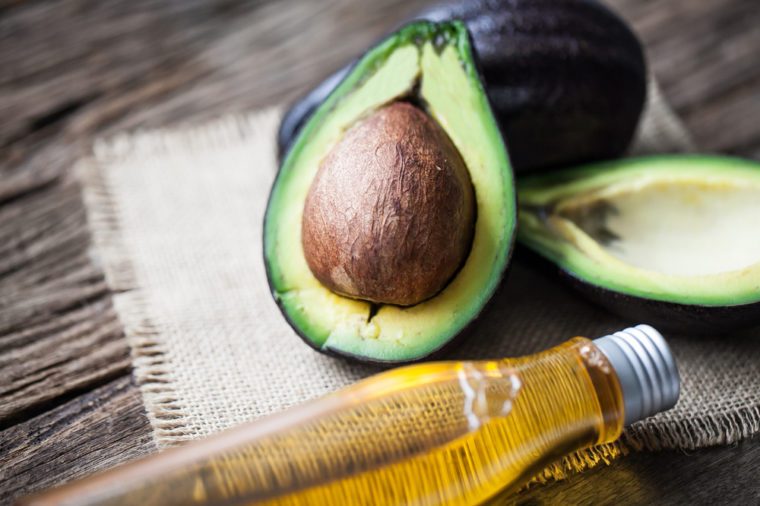avocado and avocado oil on wooden background
