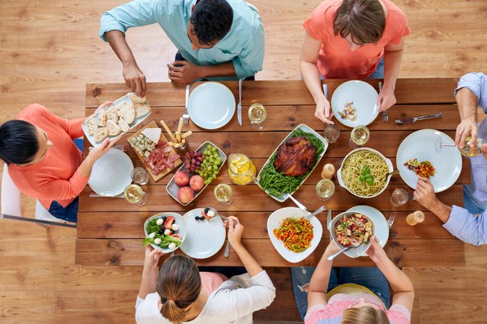 thanksgiving day, eating and leisure concept - group of people having dinner at table with food
