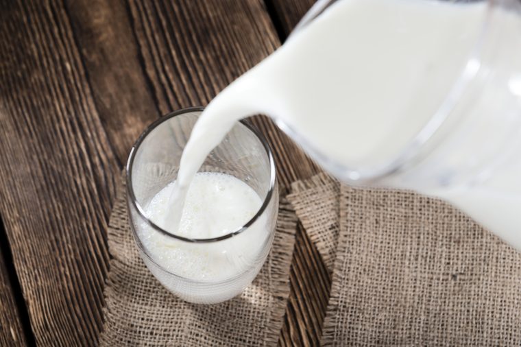 Portion of Milk on a dark wooden background (close-up shot)