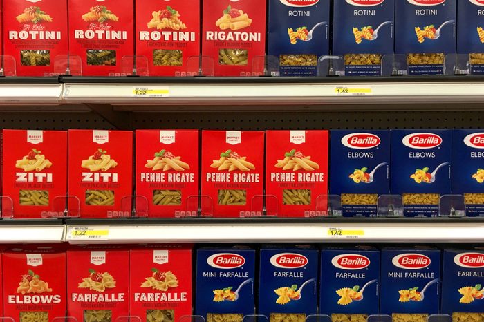 Alameda, CA - July 21, 2017: Grocery store shelf with boxes of generic brand Market Pantry pasta next to name brand Barilla pasta.