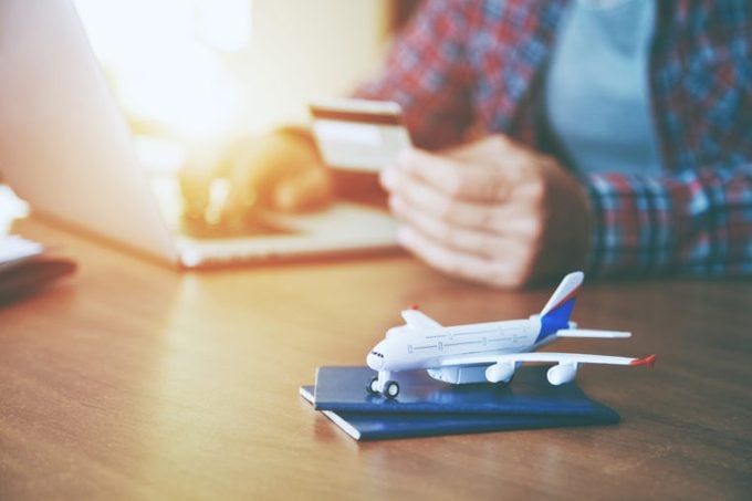 Airplane with passports near paying with credit card and laptop. Online ticket booking concept