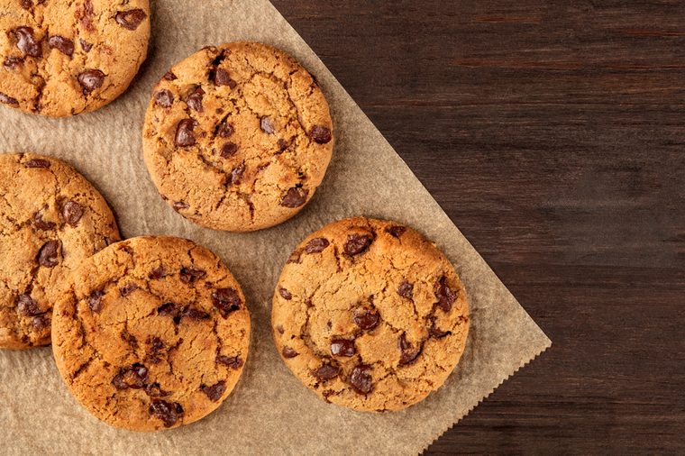 An overhead photo of chocolate chips cookies, shot from above on a piece of baking paper, with copy space