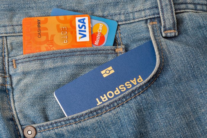 KIEV, UKRAINE - AUGUST 09, 2016: Blue biometric passport with two credit cards Visa and MasterCard in front pocket of blue jeans closeup
