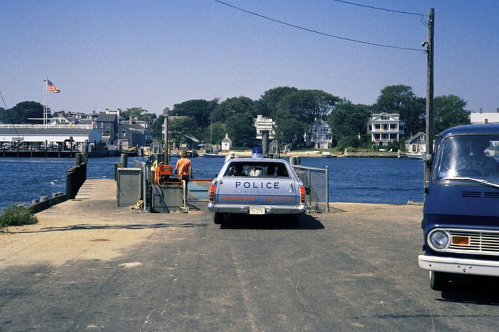 Police car waits to board and cross on ferry from Chappaquiddick Island to Edgartown, Mass. on