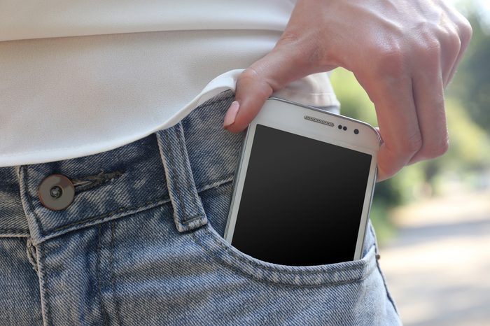 White smart mobile phone in jeans pocket