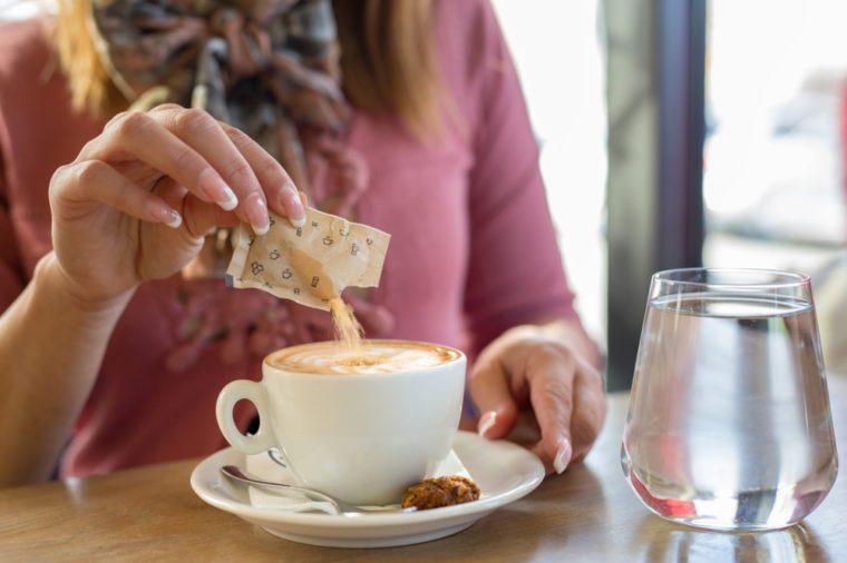 Closeup of a woman pouring sugar in her coffe daytime