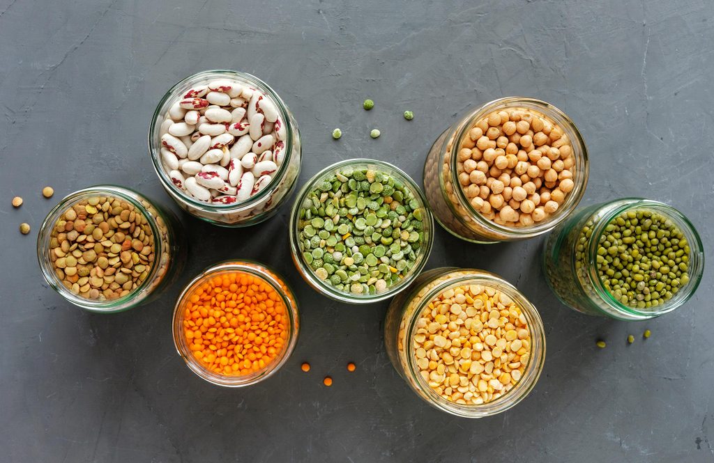 Died lentils and pulses in open glass kitchen jars for storage view top down, healthy ingredients for vegetarian cuisine