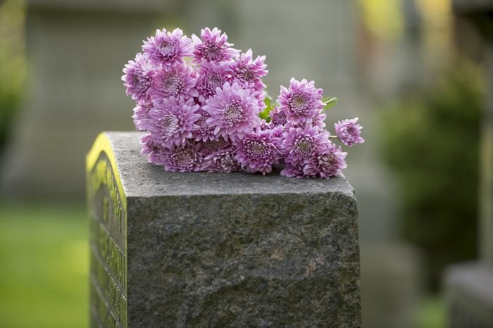 Flowers rest on headstone in cemetery