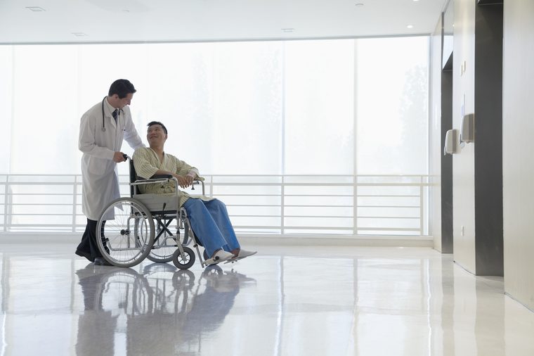 Doctor pushing and assisting patient in the hospital