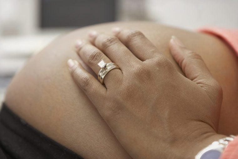 Close up of pregnant African woman's hand on bare belly