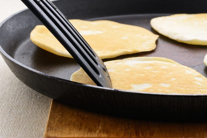 Ruddy pancakes on a black frying pan
