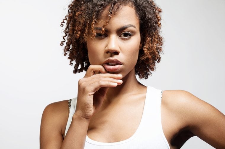 Thoughtful young black woman with clean healthy skin on a white background