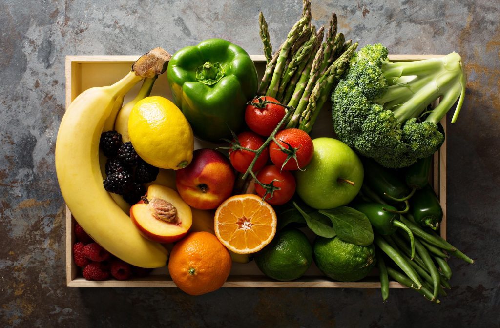 Fresh and colorful vegetables and fruits in a wooden crate