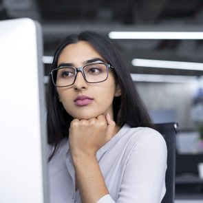 Serious young businesswoman working at computer