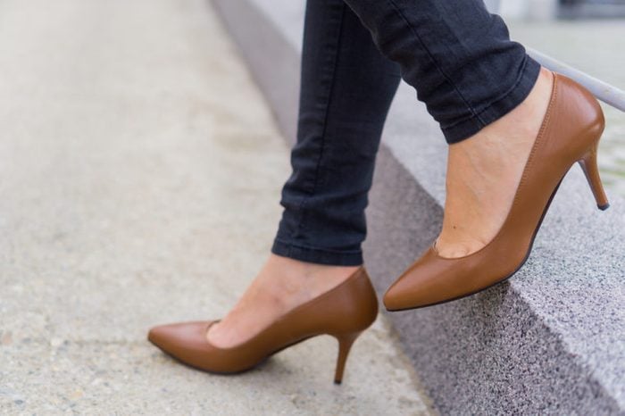 Woman wearing black jeans and high heels shoes brown