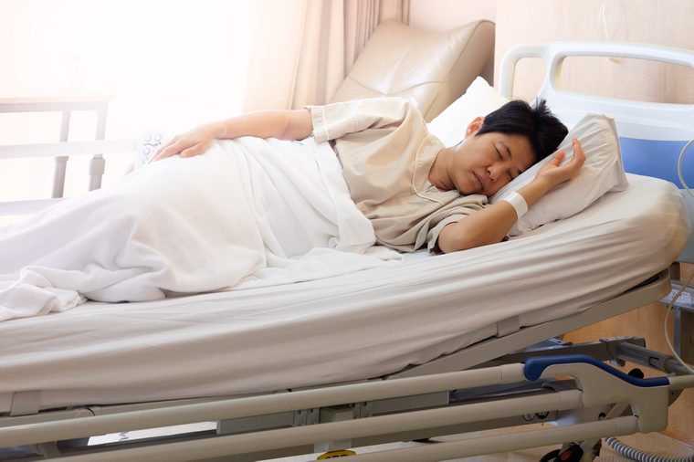 Asian woman sleeping In hospital bed, Morning sun shines into the room, AF point selection and blur.