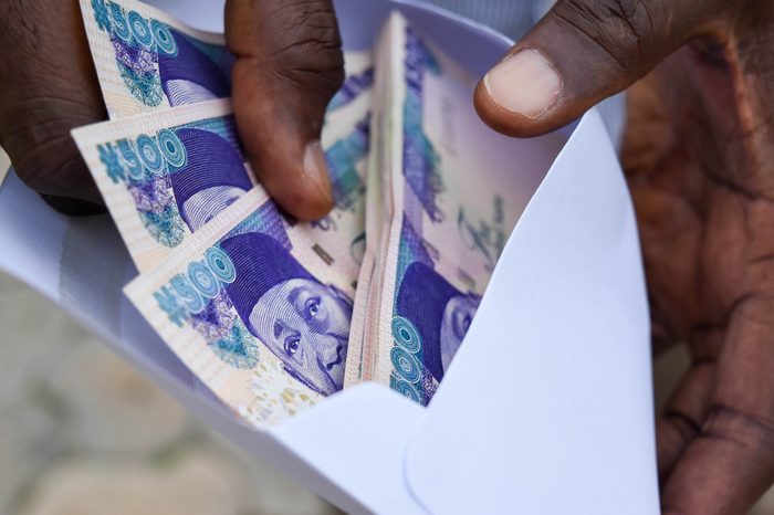 Five hundred naira notes in envelope in Dark skin fingers